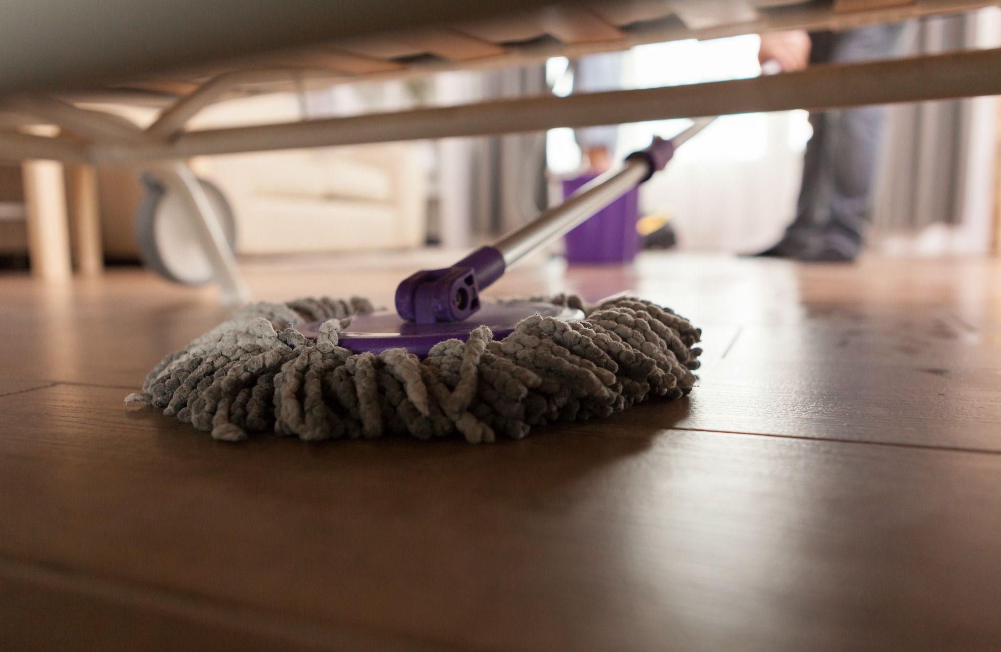 Deep cleaning under furniture in a London home